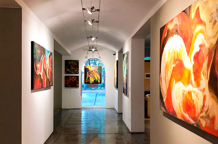 Interior gallery corridor displaying contemporary artworks prior to a private exhibition opening at Galería Oscar Román.