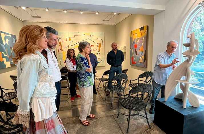 Tour group listening to the guide at Galería Oscar Román.