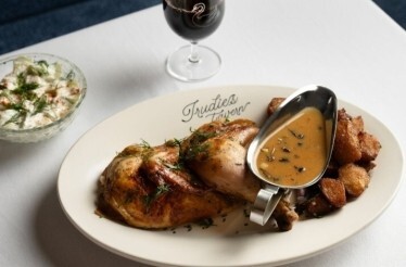 Fried chicken with baked potatoes and source paired with a glass of wine served at Trudie's Tavern.
