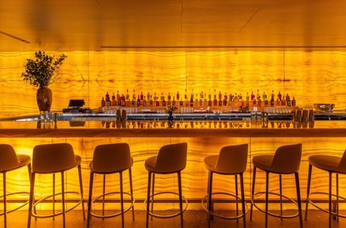 Bar counter at Marea Beverly Hills lit up with yellow light.