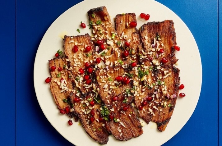 Grilled eggplant at le dräQ, garnished with pomegranate arils, chopped pine nuts, minced herbs, and a glossy dressing.