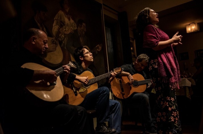 Traditional fado musicians and singer performing live at Adega Machado in Lisbon.