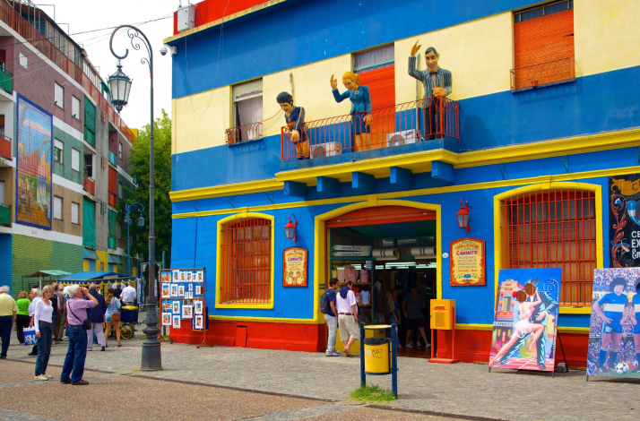Vibrant Caminito building with street art and traditional figures showcasing Buenos Aires' cultural heritage.