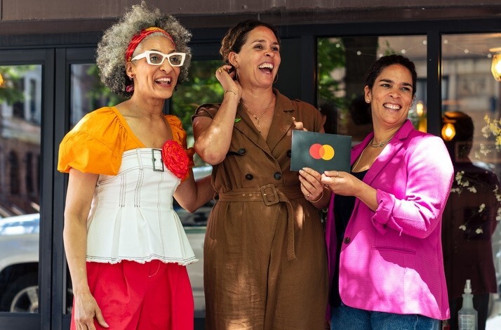 From the left: Top Chef Carla Hall and Co-owners of The Edge Harlem, Justine and Juliet, together whilst holding a Mastercard card.