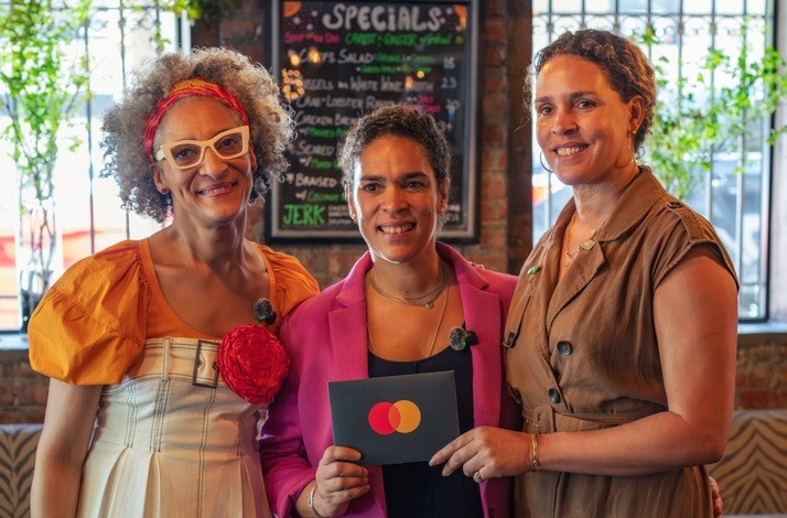 From the left: Top Chef Carla Hall and Co-owners of The Edge Harlem, Justine and Juliet, together whilst holding a Mastercard card.