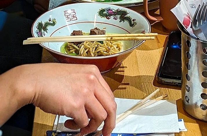 A person eating a bowl of ramen.