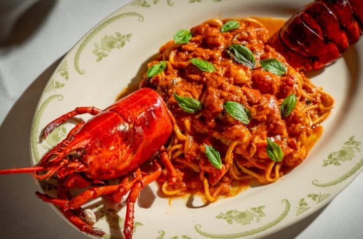 Lobster fra diavolo with spaghetti in rich tomato sauce, garnished with fresh basil leaves, served at Opto.