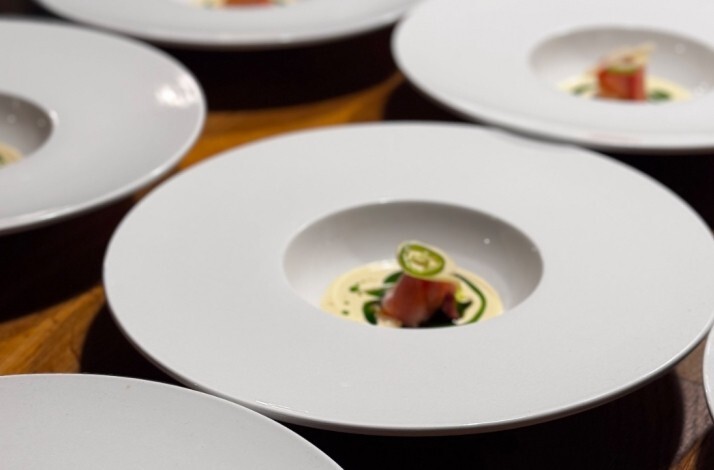 Zitz Sum tasting menu plating lineup showing minimalist wide bowls with seared fish, cream, and sliced jalapeno garnish.