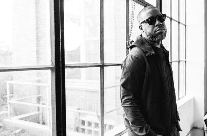Black and white photo of artist Robert Glasper Questlove Bilal leaning at the window.