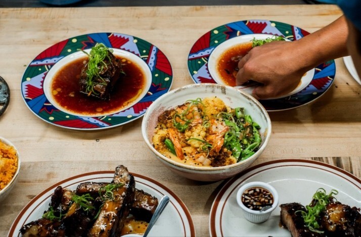 Hands plate and serve a meal of saucy ribs and a shrimp-and-vegetable bowl, served at Prubechu.