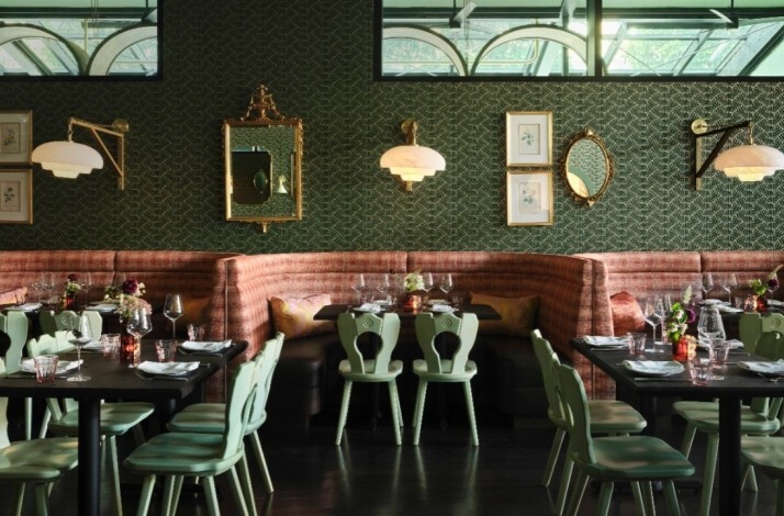 JouJou's French-California dining room with mint chairs, rose banquettes, ornate gold mirrors, patterned green walls, and elegantly set tables.