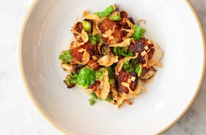 Roasted mushrooms and Brussels sprouts with crispy shallots and herbs, plated in a wide white bowl at Porto Boston.