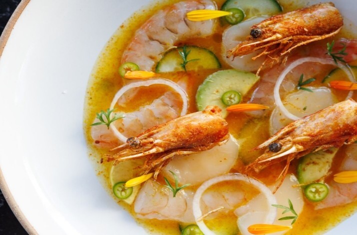 Seafood aguachile with shrimp, cucumber slices, onion rings, and sliced chiles in a citrusy golden broth at Maria Isabel.