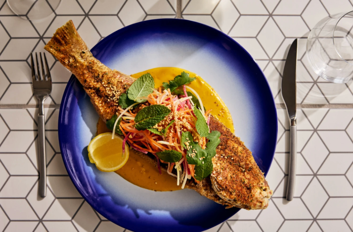 Whole spiced fish with fresh herb salad served at Superblue Miami's Blue Rider restaurant.