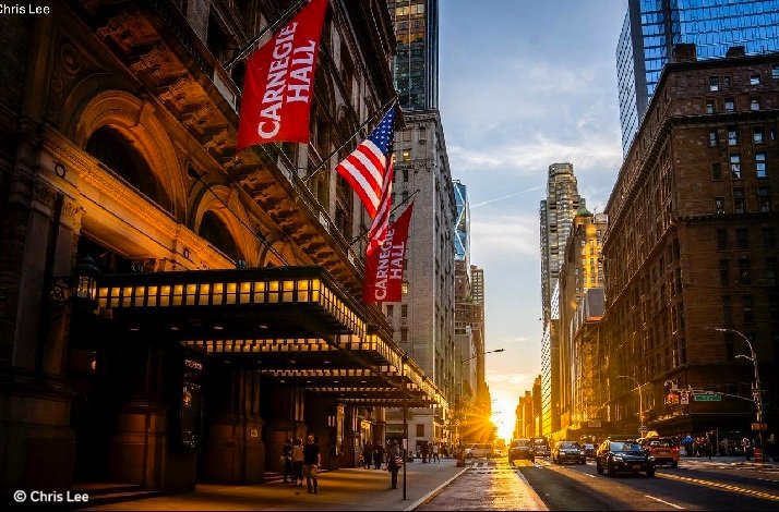 Carnegie Hall entrance with flags at sunset. © Chris Lee