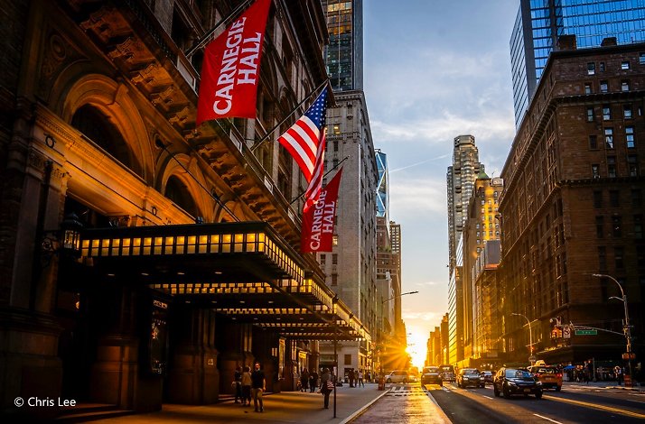 Carnegie Hall entrance with flags at sunset. © Chris Lee