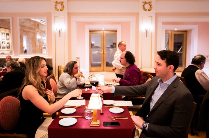 A young couple raises glasses at Weill Cafe.
