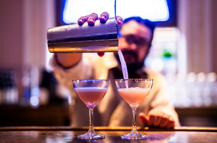  A bartender pours drinks behind the bar at Weill Cafe.