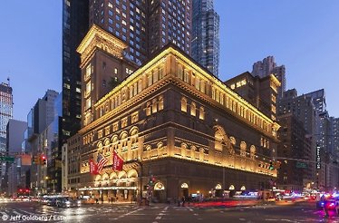 Illuminated exterior of Carnegie Hall at night with street traffic. © Jeff Goldberg / Esto