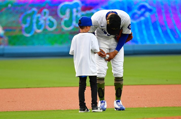 Baseball player with a boy on the field.