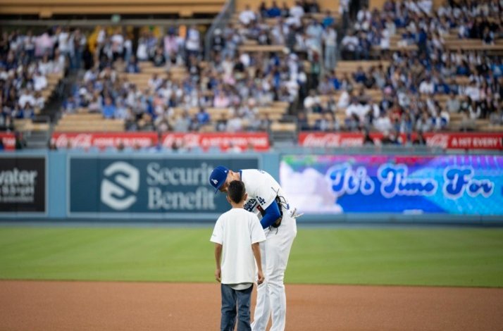 Baseball player with a boy on the field.