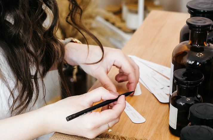 Women writes name for perfume bottle at  Perfumed Prague
