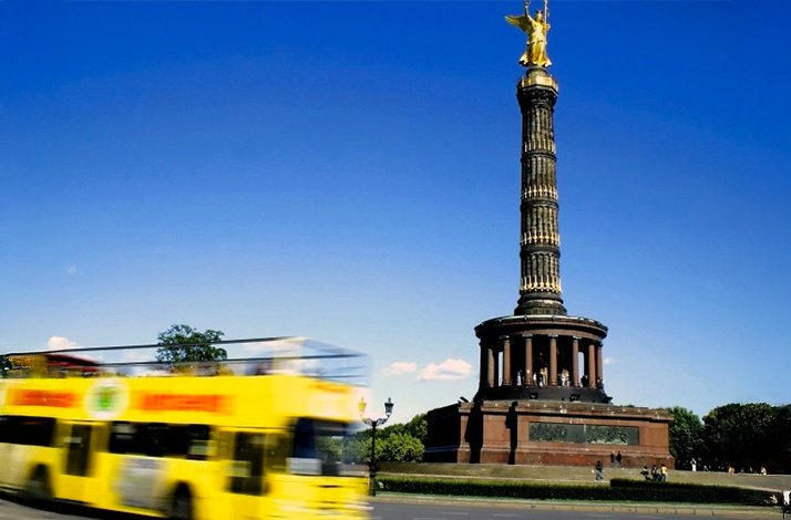 A tour bus passing by the Siegessaule. 