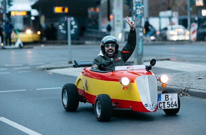 Man happy and showing peace sign in HotRod car.