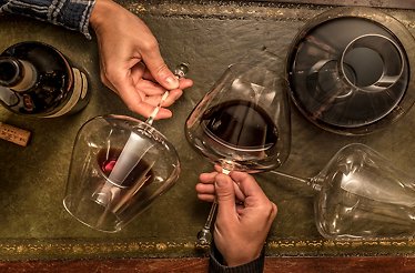 Close-up of wine glasses and a decanter on a leather mat at Little London