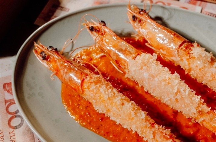Crispy fried shrimp arranged neatly on a plate with savory red sauce.