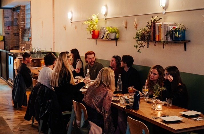 A crowd talking inside of Tang restaurant.