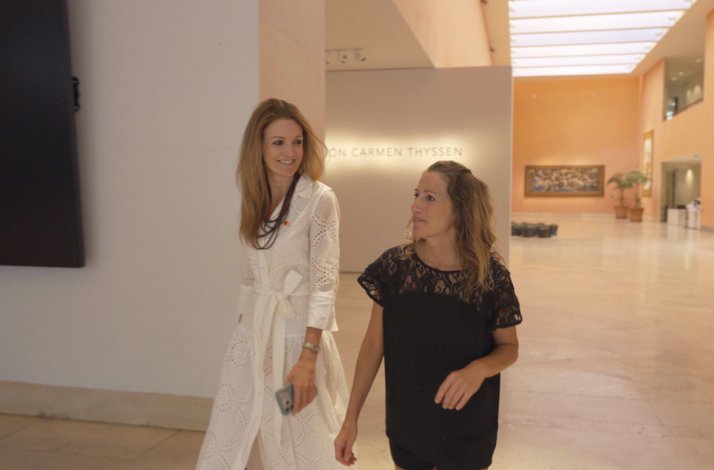 Susana Rubio and Andrea Velasco talking while walking through a Carmen Thyssen gallery hall.