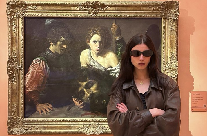 Woman posing in front of a classic painting at Thyssen-Bornemisza Museum.