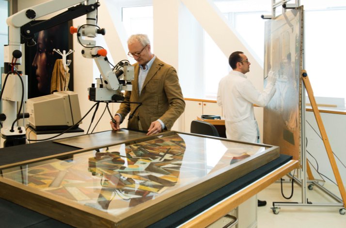 Restorers are working on restoring paintings with equipment for this purpose at the Thyssen Museum.