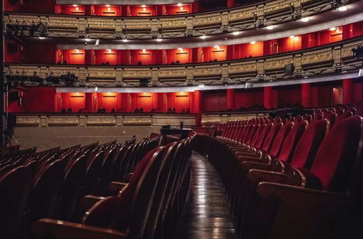Magestic stage view framed by red curtains and opulent golden balconies