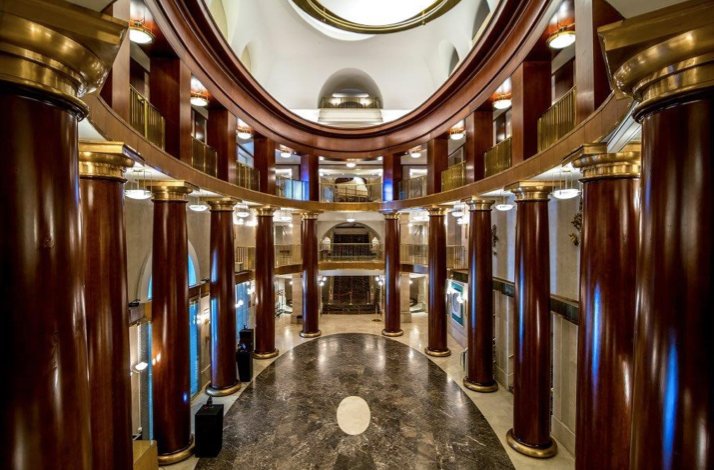 Elegant lobby with marble floor, tall columns, and golden accents in Teatro Real.