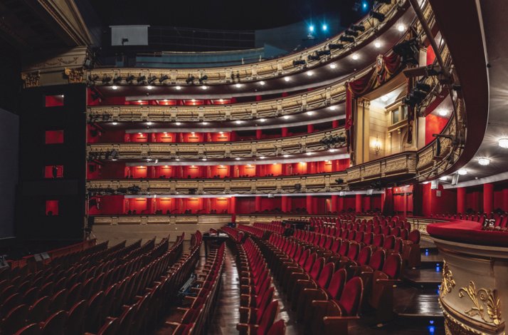 Wide view of Teatro Real’s auditorium with red seats and golden balconies.