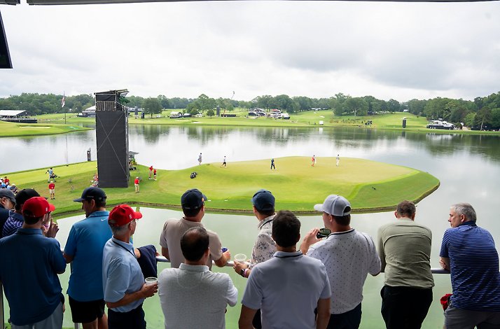 Group of golfers overlooking the East Lake Golf Club playing field by the water.