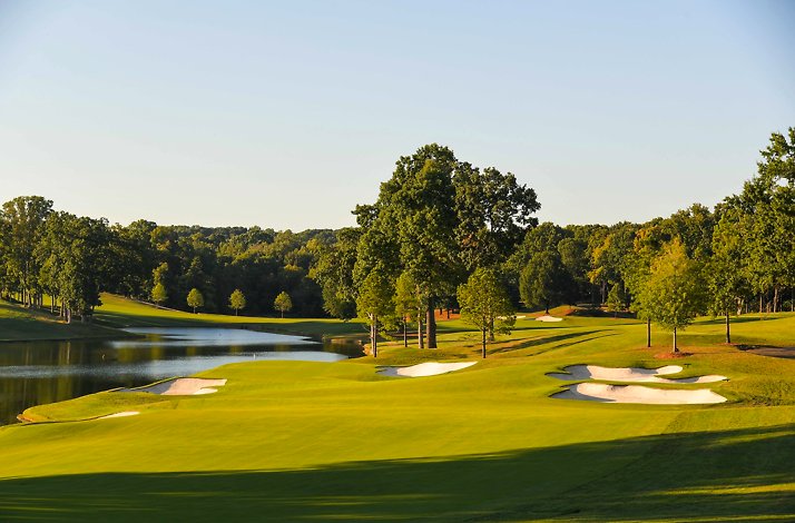 An expansive view of the Quail Hollow Club golf course under a clear sky.