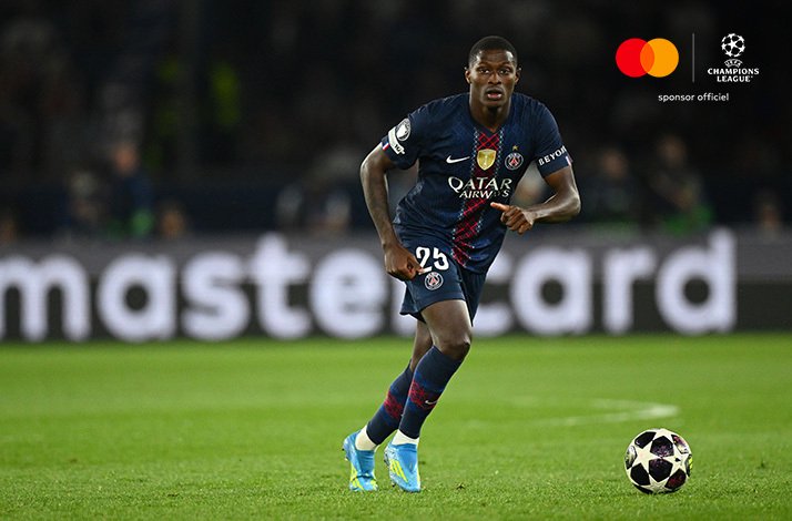 PSG player wearing number 25 dribbling with ball on pitch during UEFA Champions League quarter-final.