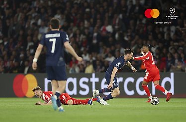 PSG midfielder dribbling past fallen Bayern player with Fabian Ruiz visible in background during Champions League semi-final.