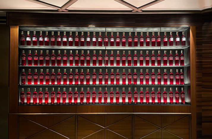 Red bottles neatly arranged on shelves at Camparino in Galleria.