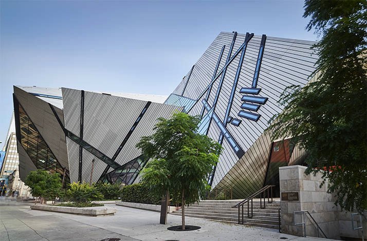 The outside of ROM with trees growing on the sidewalks.