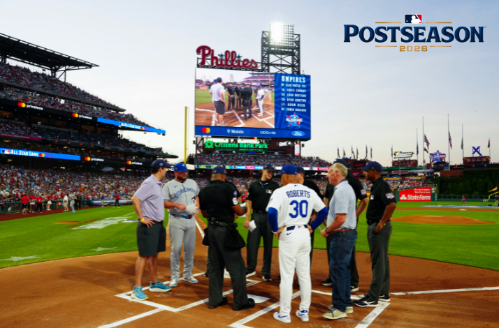 Pre-game home plate meeting at Citizens Bank Park featuring manager Dave Roberts (#30) and umpires; 'POSTSEASON 2026' logo upper-right.