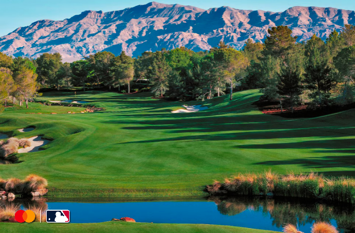 Lush fairways and sand bunkers of Shadow Creek golf course in Las Vegas, with mountain backdrop. Mastercard and MLB logos in lower-left corner.