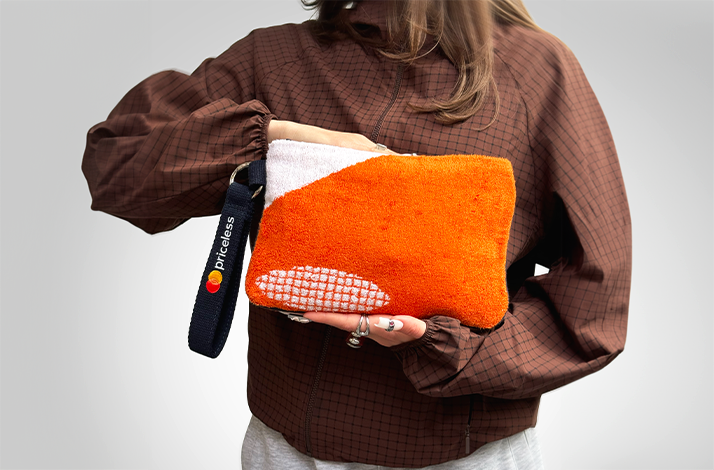 A person holding a pochette made from upcycled Roland-Garros 2025 towels.