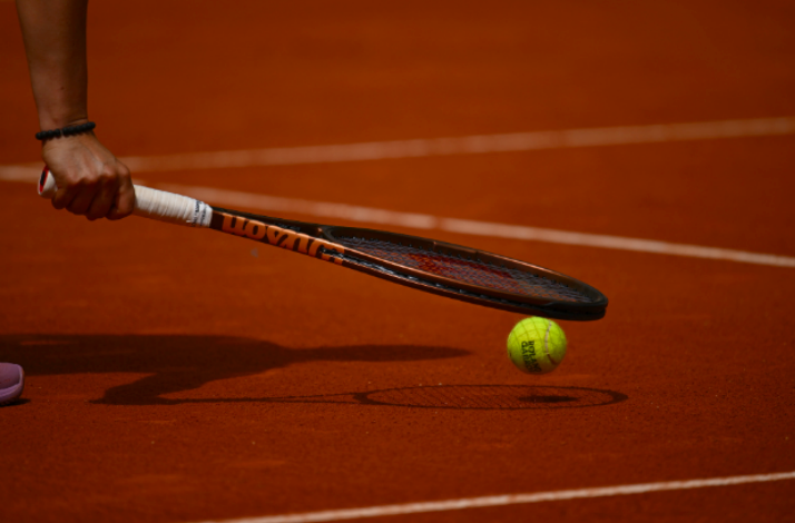 A close up photo of a tennis racket and a ball