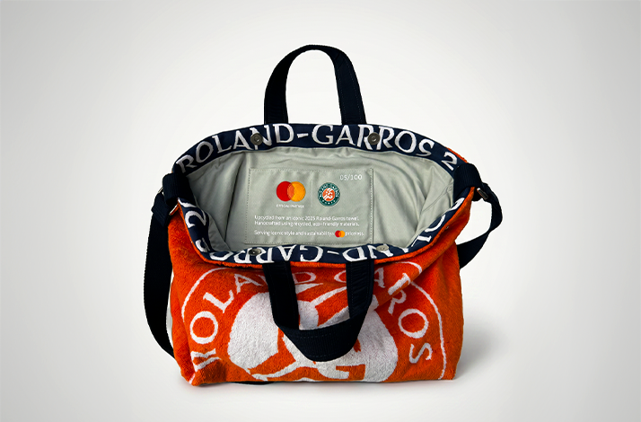 Interior view of orange Roland-Garros towel bag showing gray lining with Mastercard and Roland-Garros logos, limited-edition number 