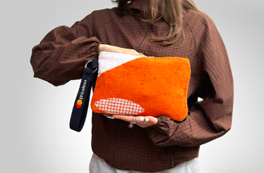 A person holding a pochette made from upcycled Roland-Garros 2025 towels.