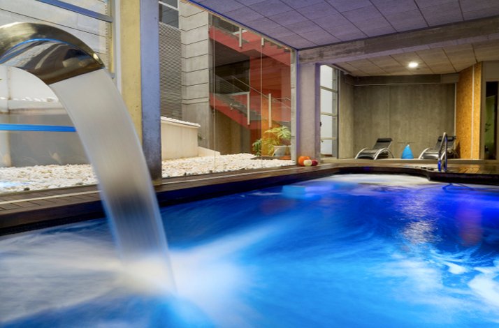 Indoor spa pool with water jets and a serene ambiance.